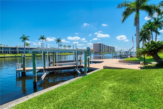 view of dock with a water view and a lawn