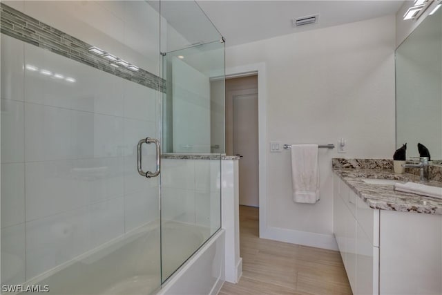 bathroom with vanity and combined bath / shower with glass door