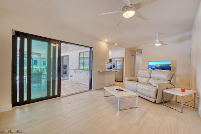 living room featuring ceiling fan and light wood-type flooring