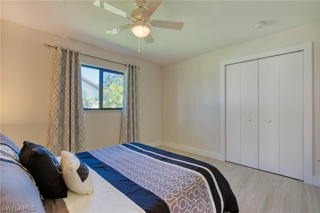 bedroom with ceiling fan, a closet, and light hardwood / wood-style flooring