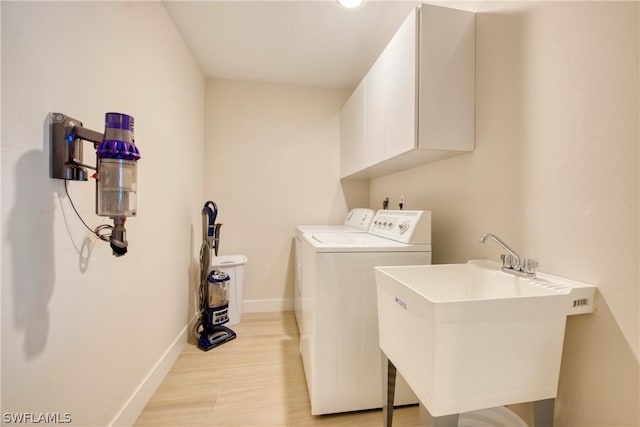 laundry room with separate washer and dryer, sink, and cabinets