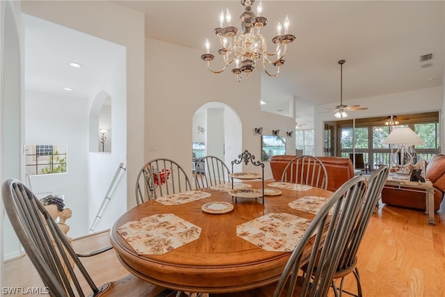 dining room featuring ceiling fan with notable chandelier and light wood-type flooring