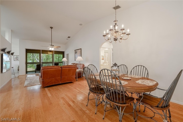 dining area featuring ceiling fan with notable chandelier, light wood-type flooring, and lofted ceiling