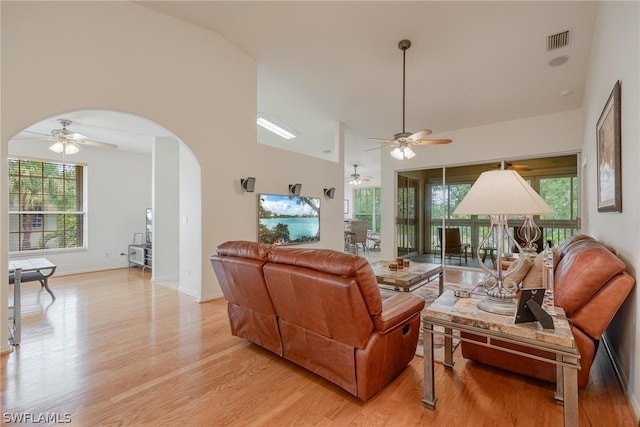 living room featuring high vaulted ceiling, ceiling fan, and light wood-type flooring