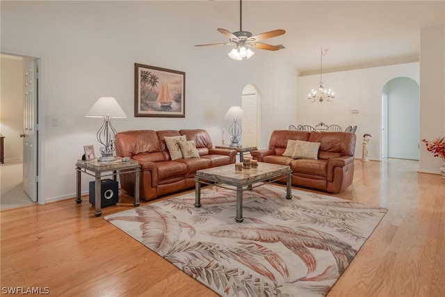 living room with ceiling fan with notable chandelier and hardwood / wood-style floors