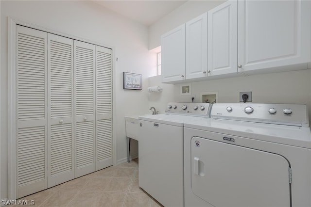 washroom featuring light tile flooring, washing machine and dryer, washer hookup, electric dryer hookup, and cabinets