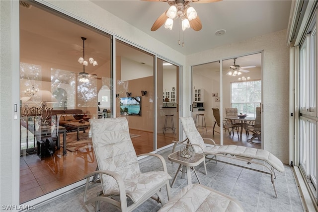 interior space with ceiling fan with notable chandelier