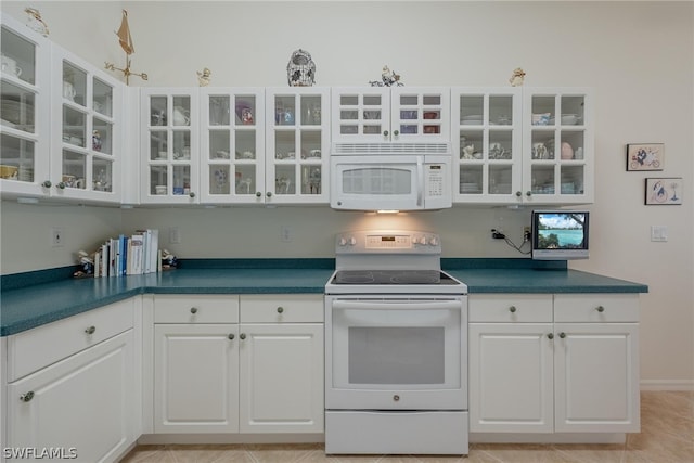 kitchen featuring white cabinetry, white appliances, and light tile floors