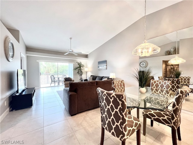 tiled dining space featuring ceiling fan with notable chandelier and vaulted ceiling