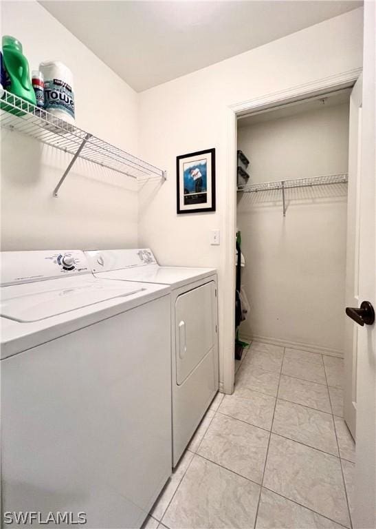 laundry area featuring light tile patterned floors and washing machine and clothes dryer