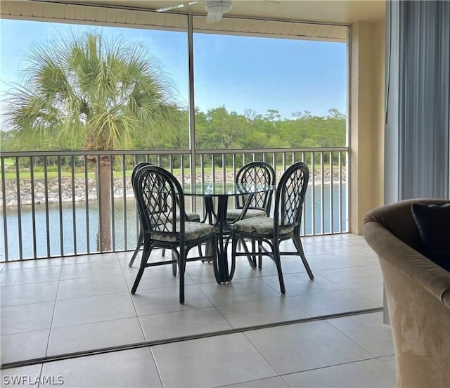 balcony featuring a water view and ceiling fan