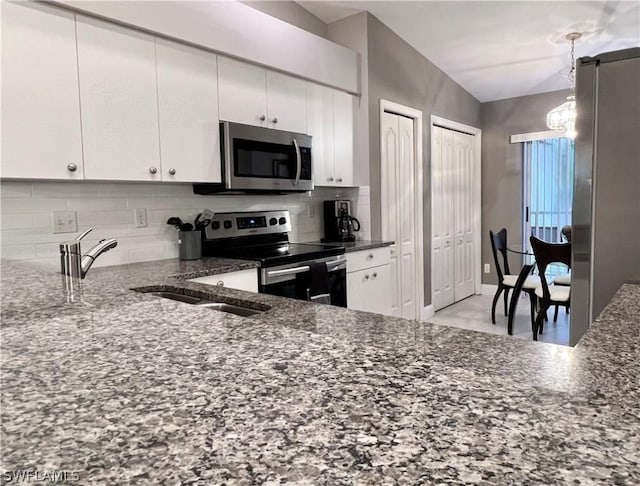 kitchen featuring sink, appliances with stainless steel finishes, tasteful backsplash, decorative light fixtures, and white cabinetry