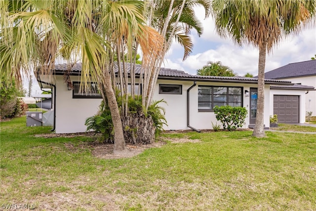 view of front of house with a garage and a front lawn