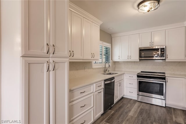 kitchen with stainless steel appliances, backsplash, white cabinetry, dark wood-type flooring, and sink