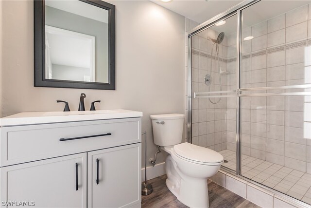 bathroom with walk in shower, oversized vanity, toilet, and hardwood / wood-style floors