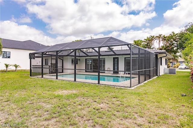 view of pool featuring a patio area, glass enclosure, and a yard