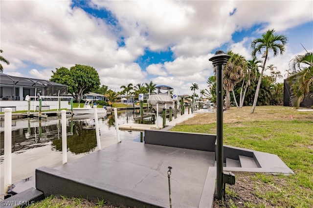 dock area with a lawn and a water view