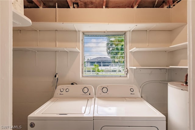 clothes washing area with washer and dryer and water heater