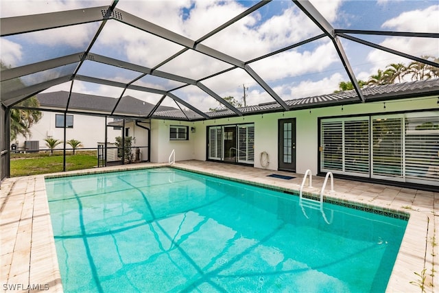 view of swimming pool with glass enclosure and a patio area