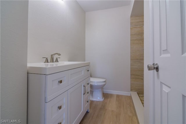 bathroom featuring toilet, vanity, and hardwood / wood-style floors