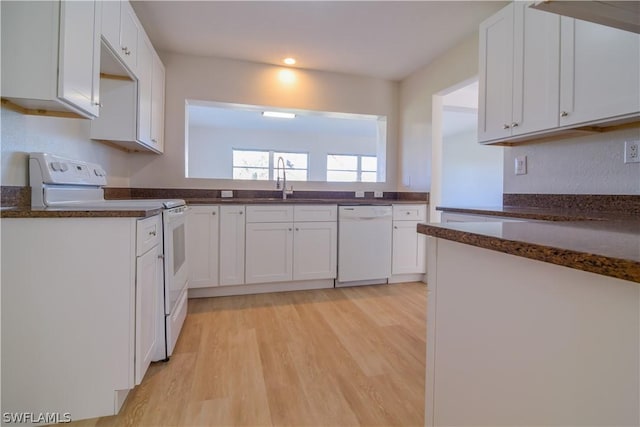 kitchen featuring white cabinets, light wood-type flooring, sink, and white appliances