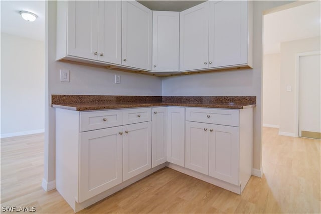 kitchen with white cabinetry and light hardwood / wood-style flooring