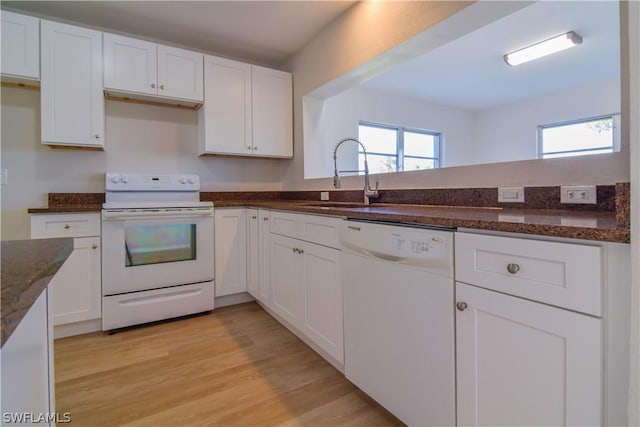 kitchen with white cabinetry, white appliances, dark stone counters, light hardwood / wood-style flooring, and sink