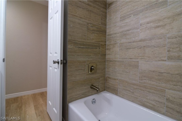 bathroom with tiled shower / bath combo and hardwood / wood-style flooring