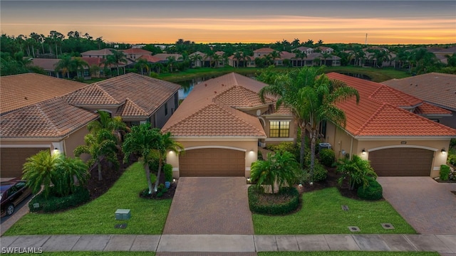 11643 Meadowrun Cir, Fort Myers, FL 33913 - view of front facade with decorative driveway, a garage, stucco siding, a residential view, and a tiled roof
