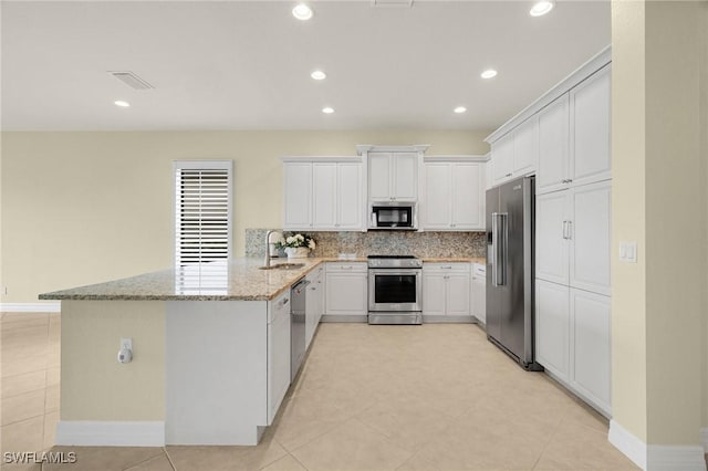 11643 Meadowrun Cir, Fort Myers, FL 33913 - kitchen featuring stainless steel appliances, a peninsula, backsplash, white cabinetry, and a sink