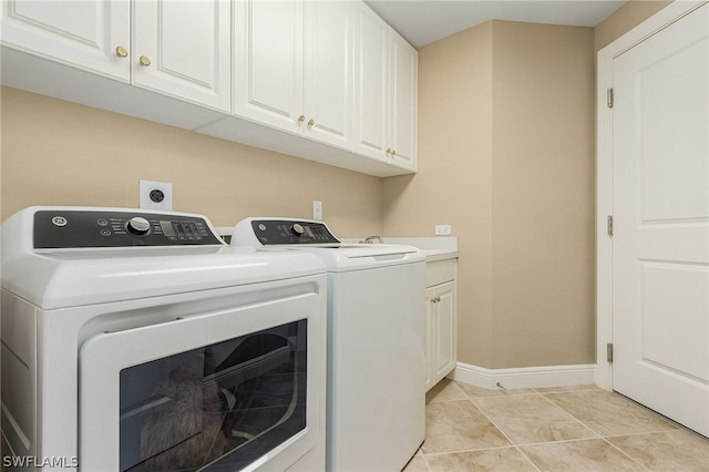 laundry area featuring washer and dryer, cabinets, light tile floors, and electric dryer hookup