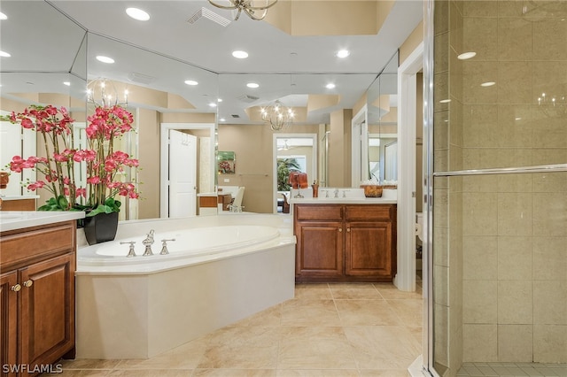 bathroom featuring tile floors, vanity with extensive cabinet space, a chandelier, and independent shower and bath