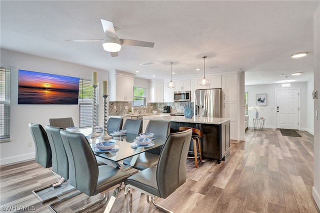 dining space with sink, ceiling fan, and light hardwood / wood-style floors