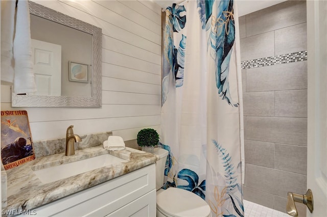 bathroom with curtained shower, toilet, wooden walls, and vanity