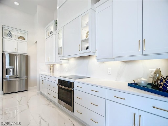 kitchen featuring white cabinets, backsplash, and stainless steel appliances