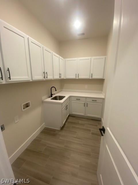 laundry room with cabinets, sink, hookup for a washing machine, and dark wood-type flooring