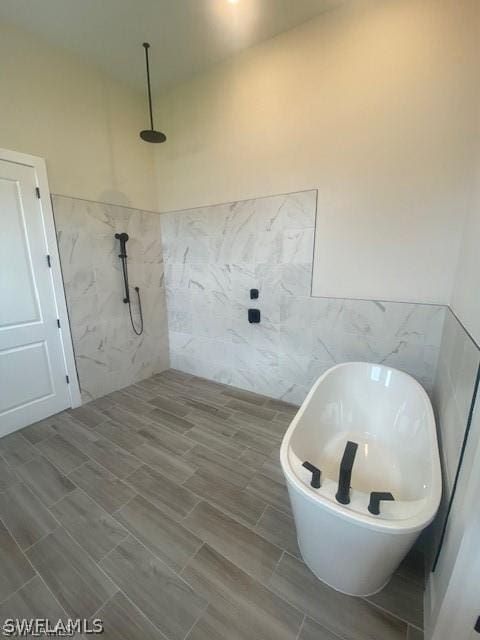 bathroom with tile walls and independent shower and bath