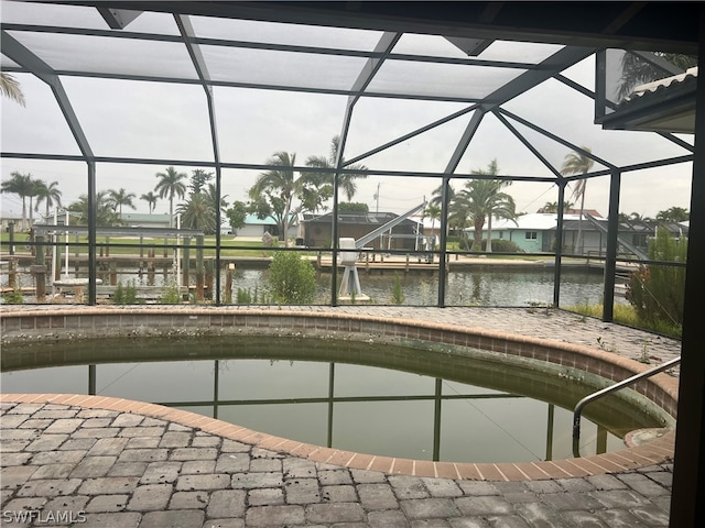 view of swimming pool with a water view and a lanai