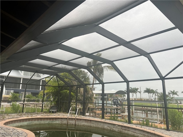 view of pool featuring a lanai and a water view