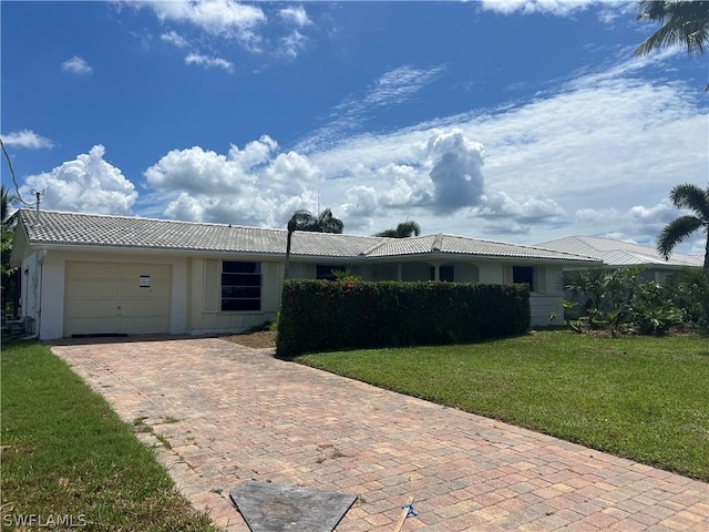 single story home with a garage and a front lawn