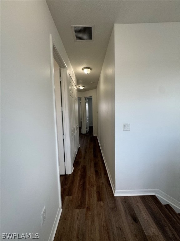 corridor featuring dark wood-type flooring