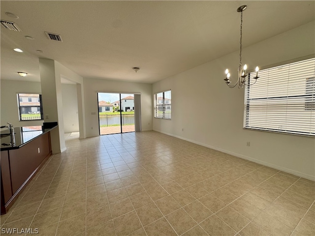 unfurnished living room featuring a notable chandelier and light tile flooring