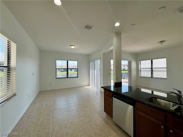 kitchen featuring sink, stainless steel dishwasher, and light tile floors