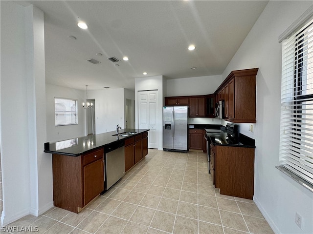 kitchen with hanging light fixtures, a kitchen island with sink, light tile floors, and stainless steel appliances