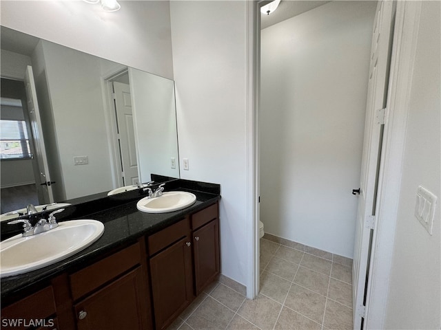 bathroom with tile floors, toilet, and dual bowl vanity