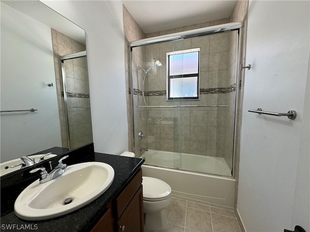 full bathroom featuring tile flooring, combined bath / shower with glass door, vanity, and toilet