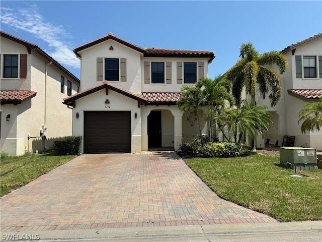 mediterranean / spanish home with a garage, a front yard, and central AC unit