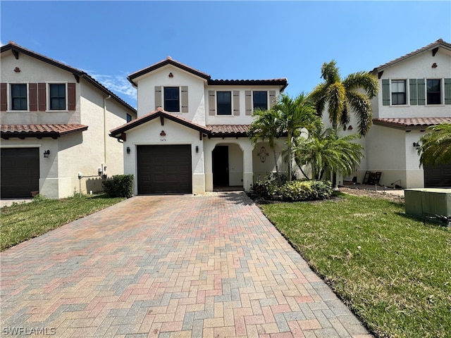 mediterranean / spanish home with a front lawn, a garage, and central AC unit