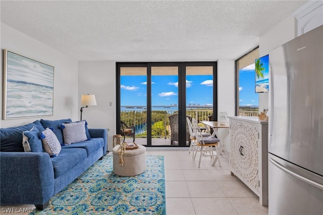 tiled living room featuring a wall of windows and a textured ceiling