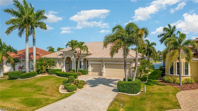 mediterranean / spanish house with a front lawn and a garage